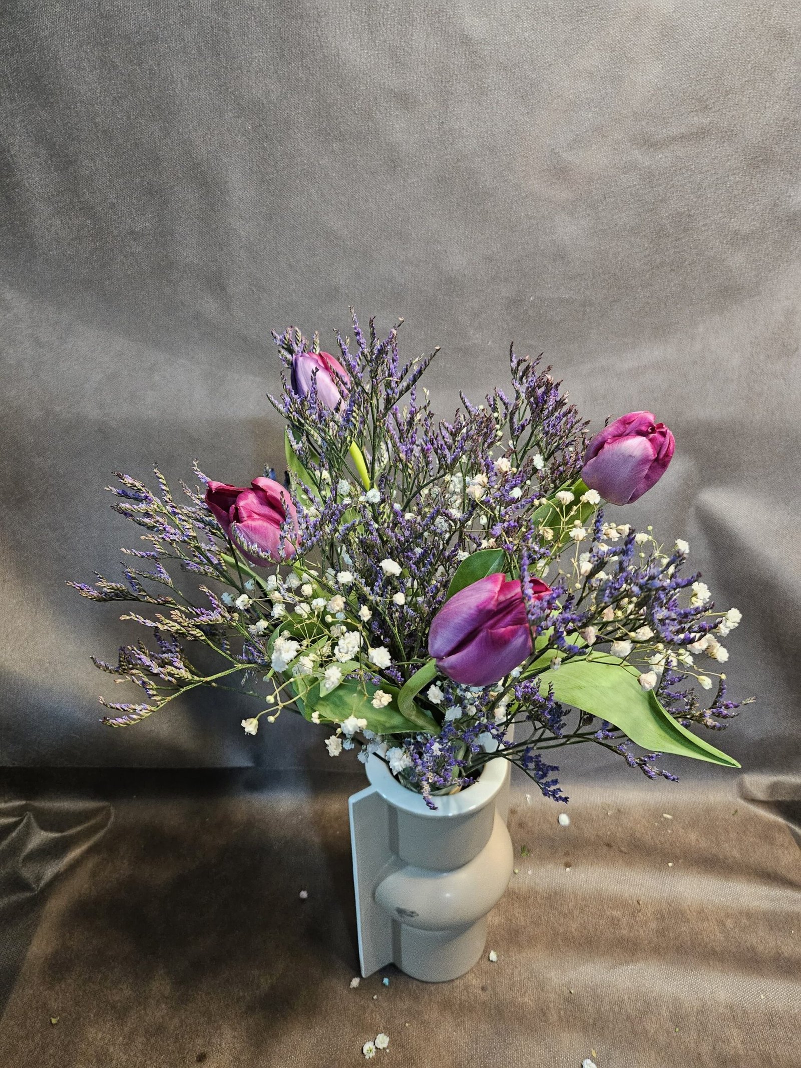 Tulipanes limón y paniculata de colores en recipiente