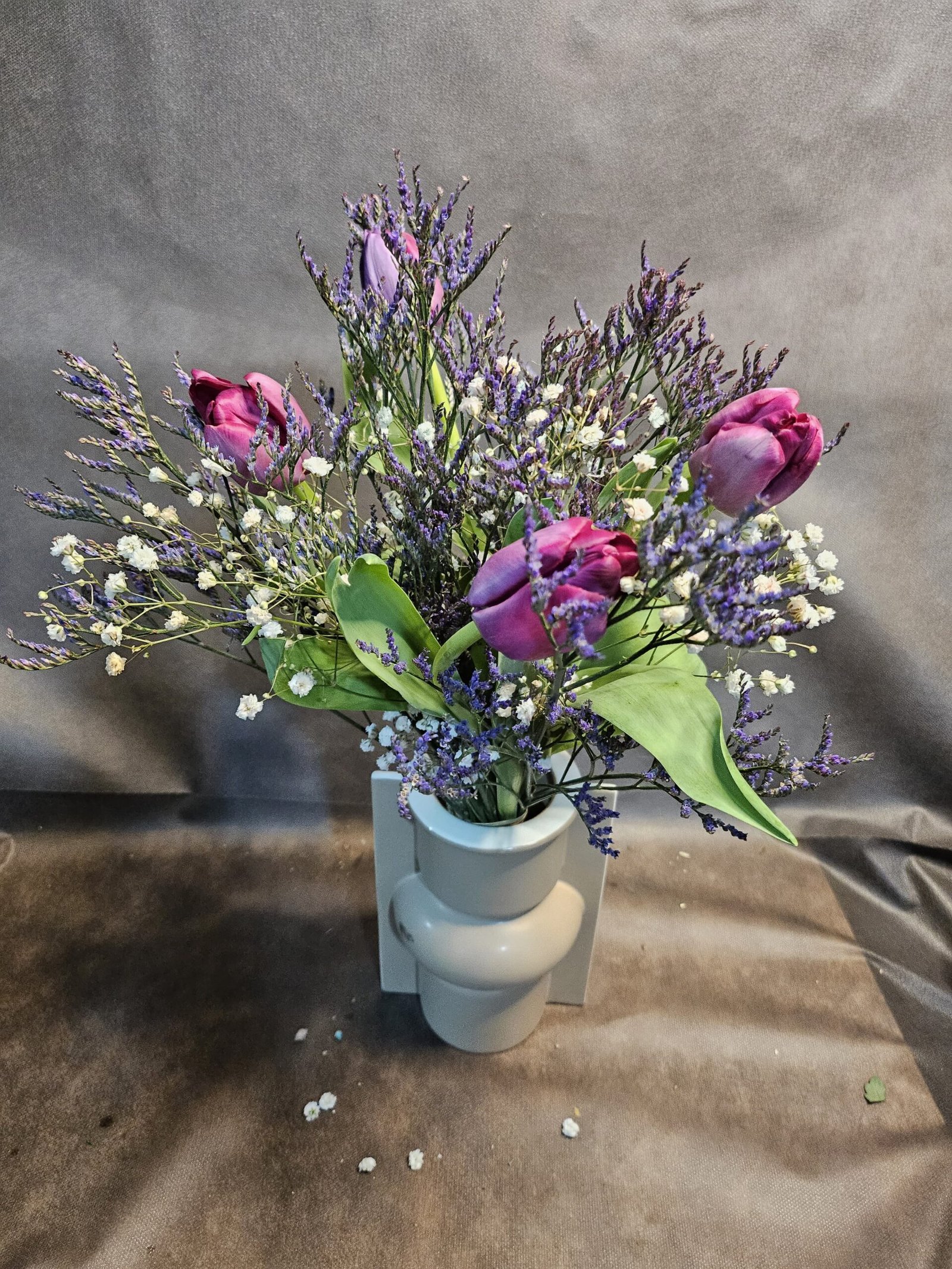 Tulipanes limón y paniculata de colores en recipient